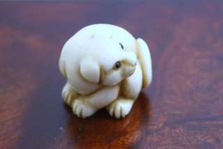 Netsuke of a dog signed by artist in fine condition. 3/4 of an inch by 