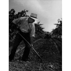  Worker Clearing a Channel in Foreground While Vehicle Is 