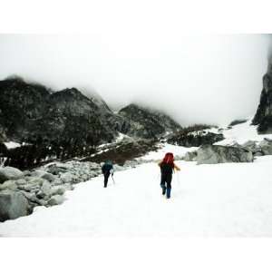 Two Climbers Ascend a Steep Snowfield to Clouds in the Wa Backcountry 