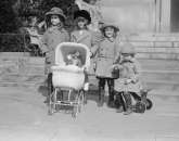 1922 4 girls pushing a doll in a toy stroller  