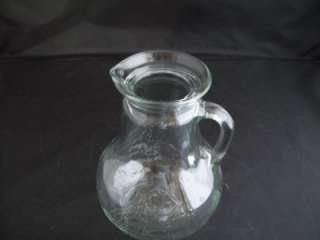Up for sale is one glass pitcher with an embossed sailboat on both 