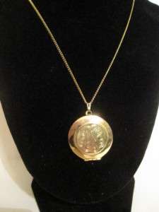   darling, gold tone necklace with locket pendant with geometric design