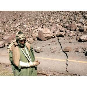 An Injured Pakistani Man Walks on an Earthquake Damaged Mountain Pass 