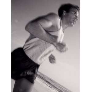  Side Profile of a Young Man Jogging on the Beach Premium 